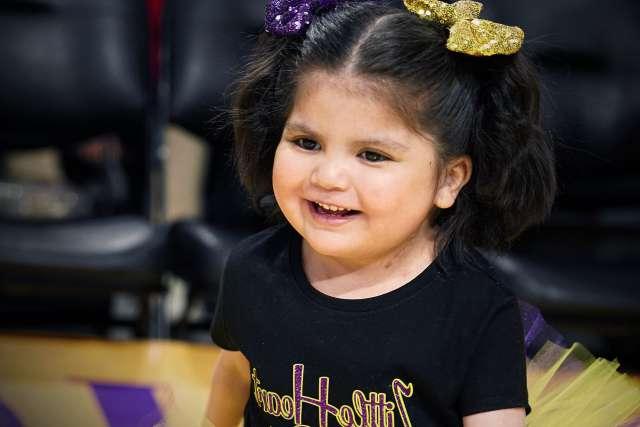 Olivia Lopez celebrates on the Los Angeles Lakers basketball court during her Laker For a Day experience.